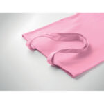 Sac en toile rose posé sur surface blanche